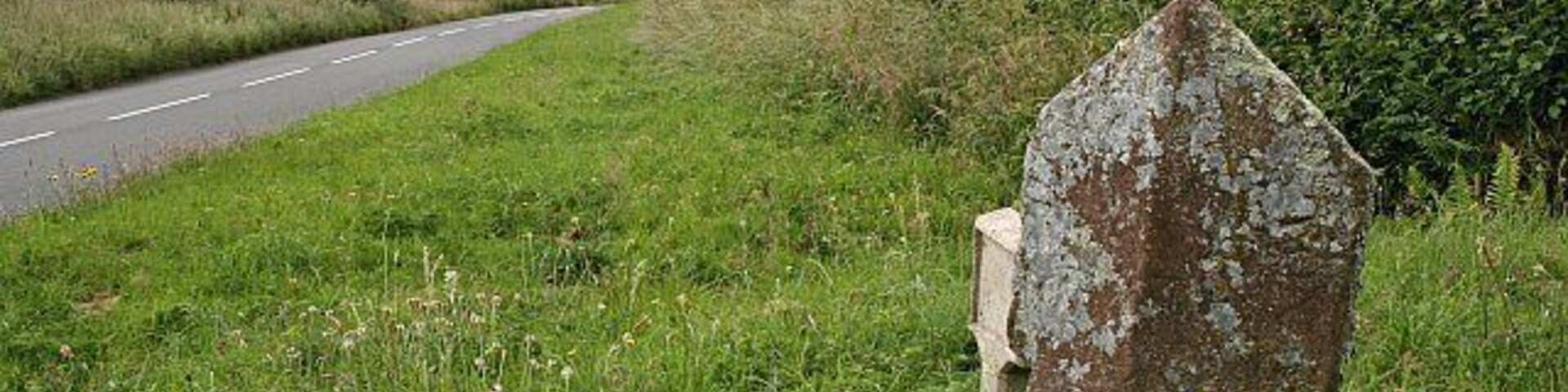 Boundary Stone and Road. It is just possible to make out the word 'Lamerton' written in a circle on the right hand face of this stone. I don't know what is written on the other face but presumably it is the name of the adjoining parish.