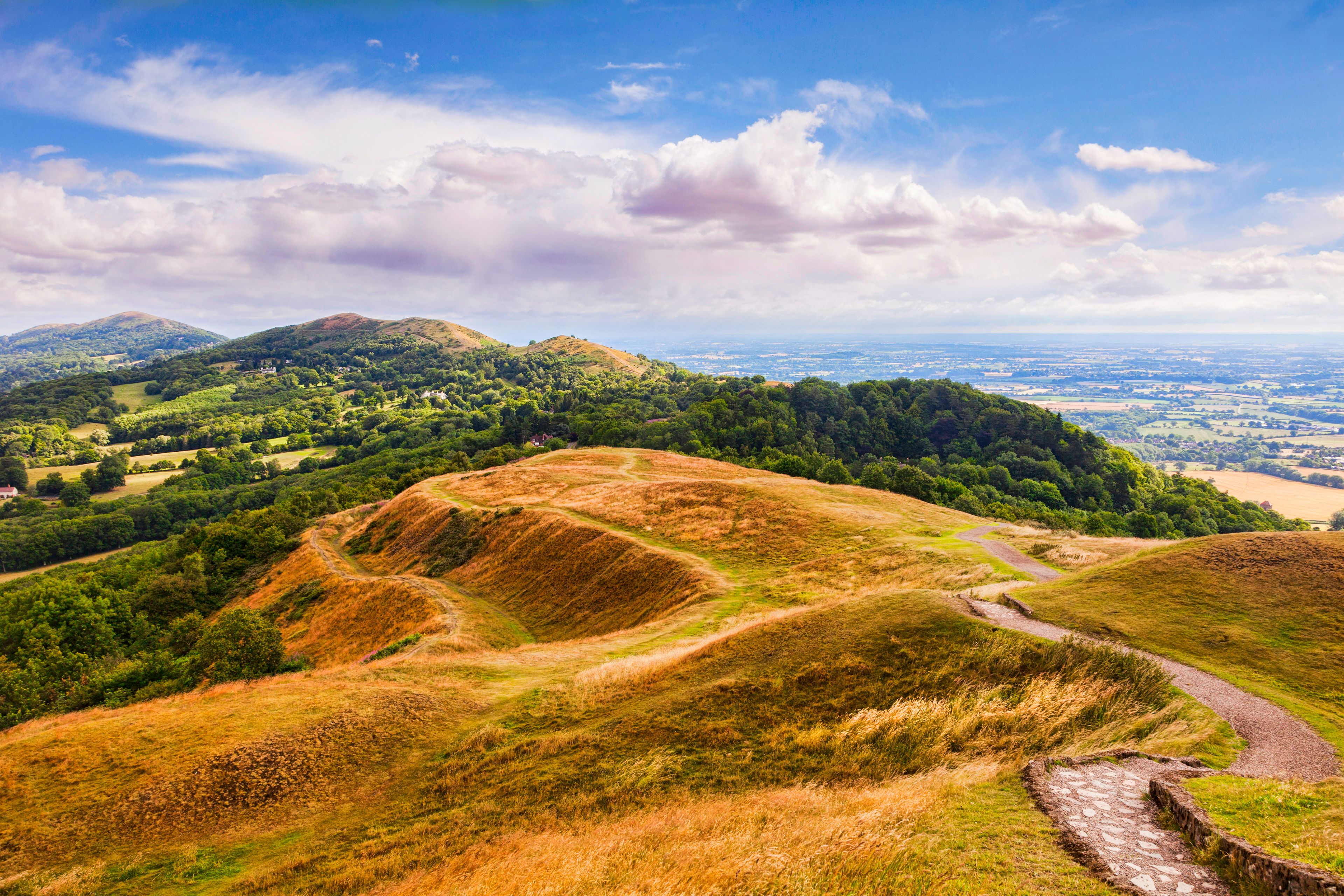 Rolling hills, a winding path, and a distant view of a valley.