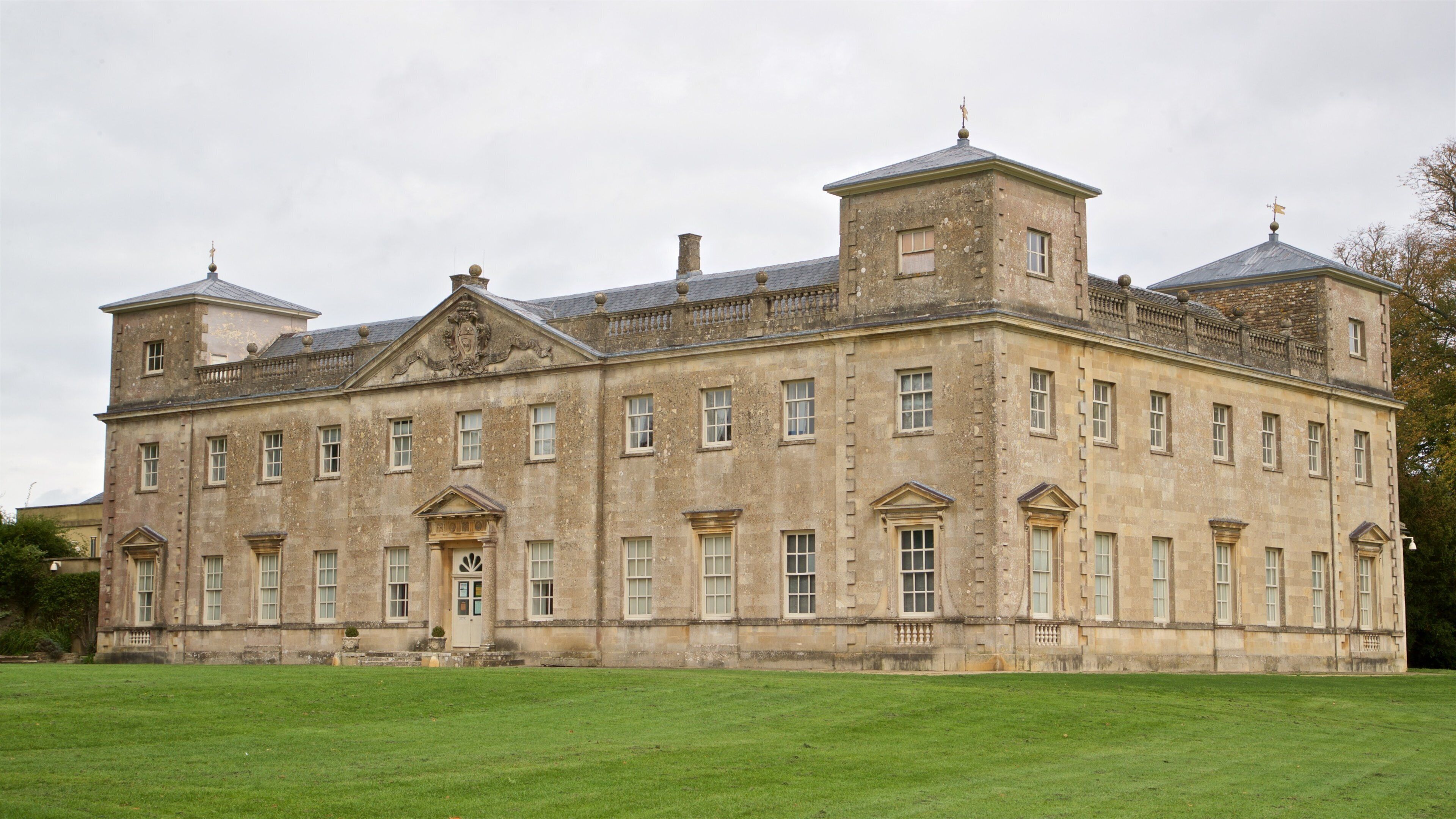 A large, historic stone building with multiple windows and a central entrance.
