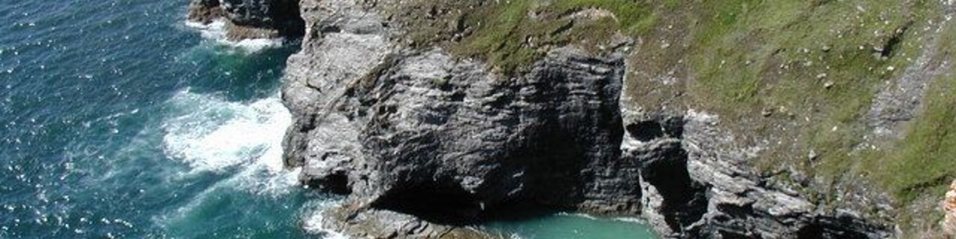 Headland north of Nancekuke Common This photo is taken from the coast path. The Gullyn Rock is shown beyond the headland.