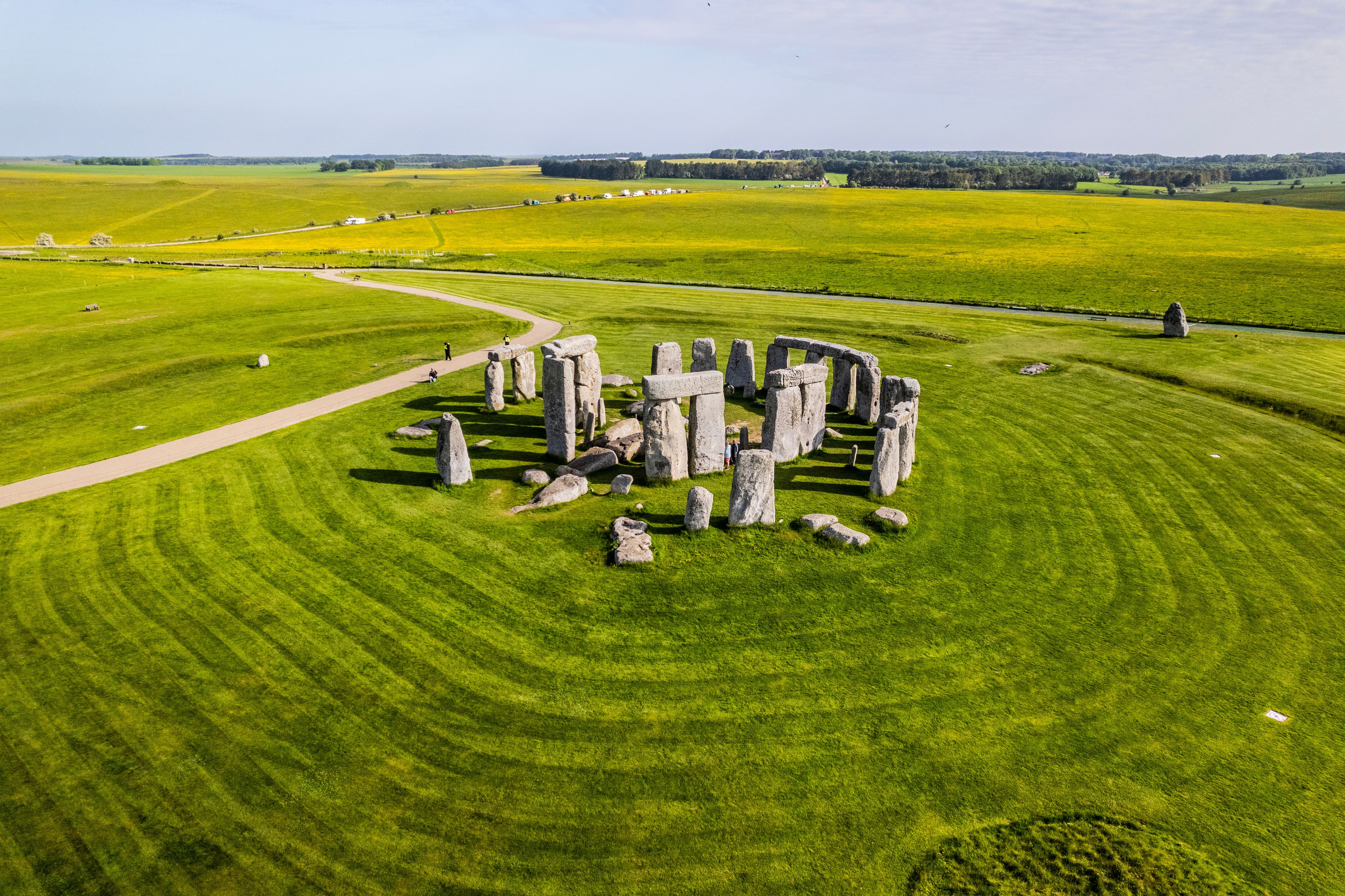 Stonehenge in a grassy field with a clear sky.