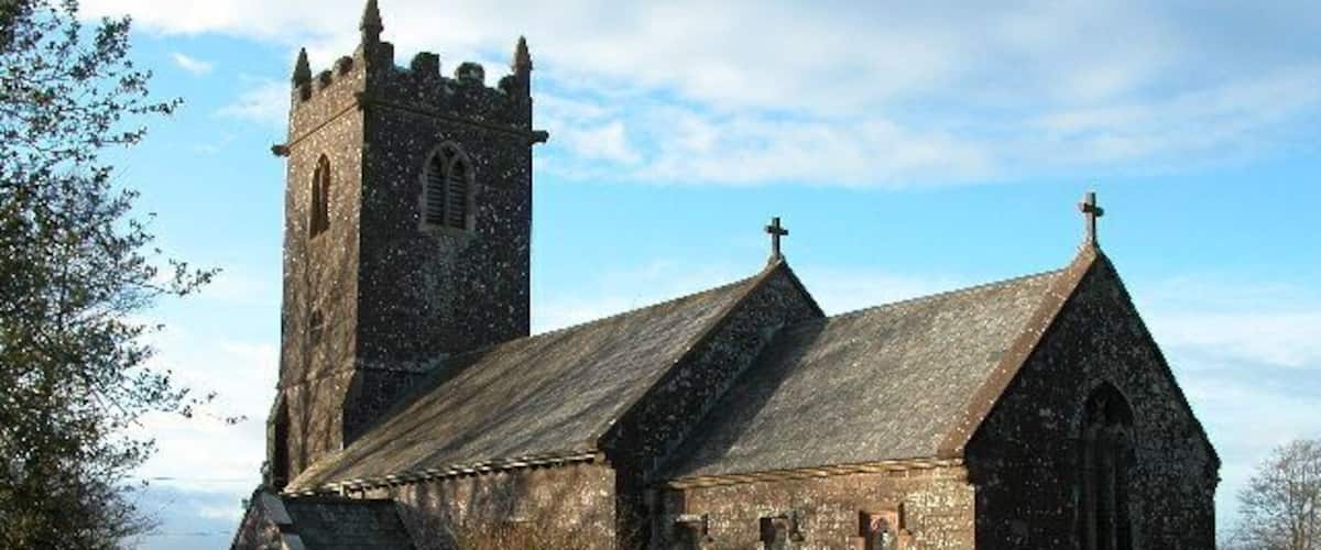 A church with a tall tower and a graveyard.
