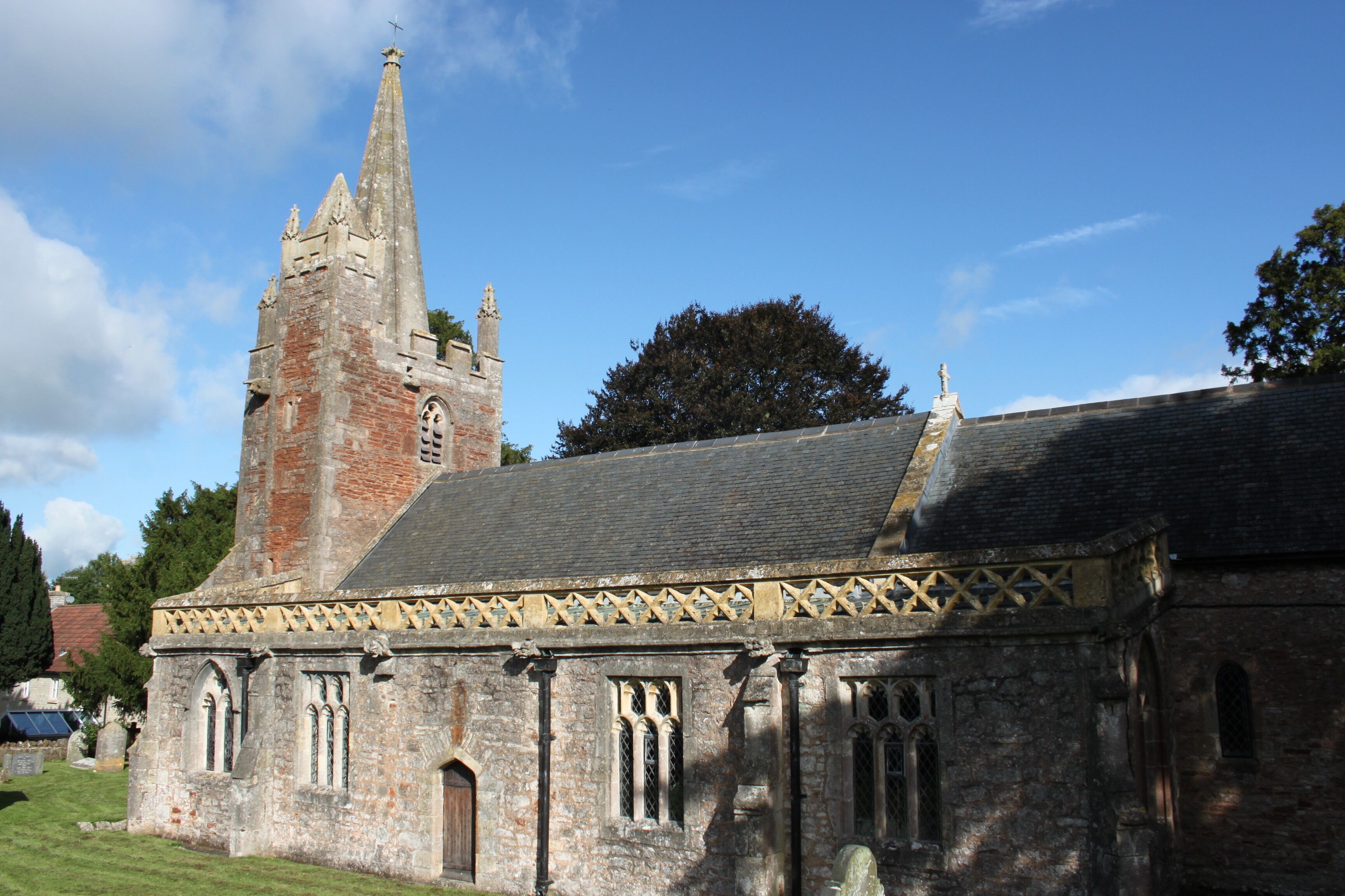 A historic church with a tall spire, arched windows, and a stone facade.