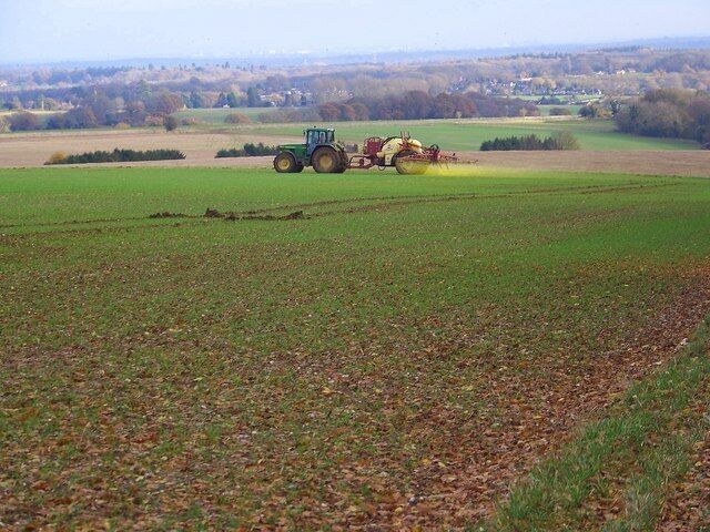 Crop spraying, Pepperbox Hill. Fortunately the driver stopped while we walked past. Southampton and Fawley can be seen on the distant horizon.