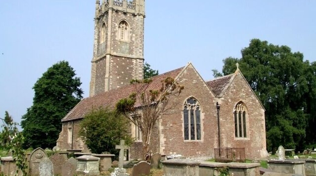 St James the Great, Westerleigh. A gateway from the recreation field to the south of the church into the churchyard, carries the dates "1304 - 2004" - this probably indicates the date of the earliest parts of this church - which I would hazard do not include most of what you see in this picture. The tower in particular looks Victorian to me. What I think is the oldest part of the church can be seen here 464276.