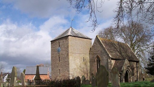 St Bartholomew's parish church, Westhide, Herefordshire. The red brick building behind the obelisk monument is the former village school