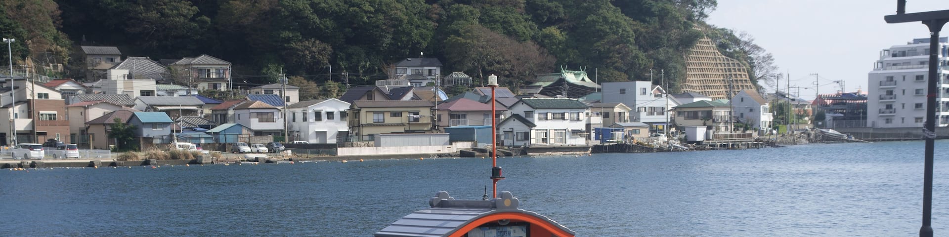 A boat docked at a pier with a cityscape in the background.