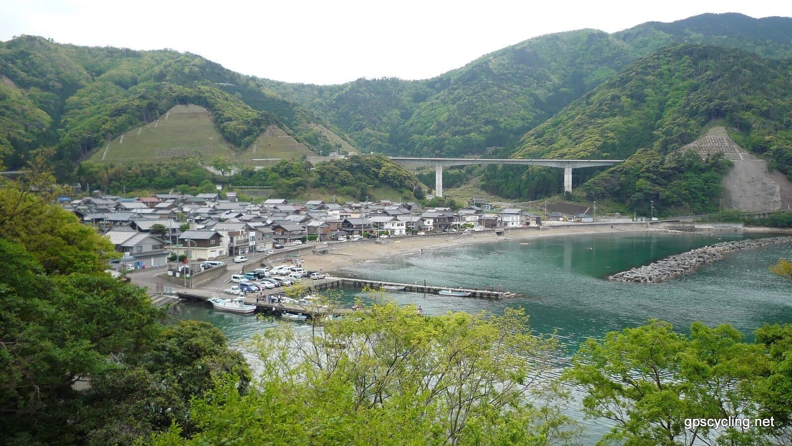 A coastal town with houses, a bridge, and a river.