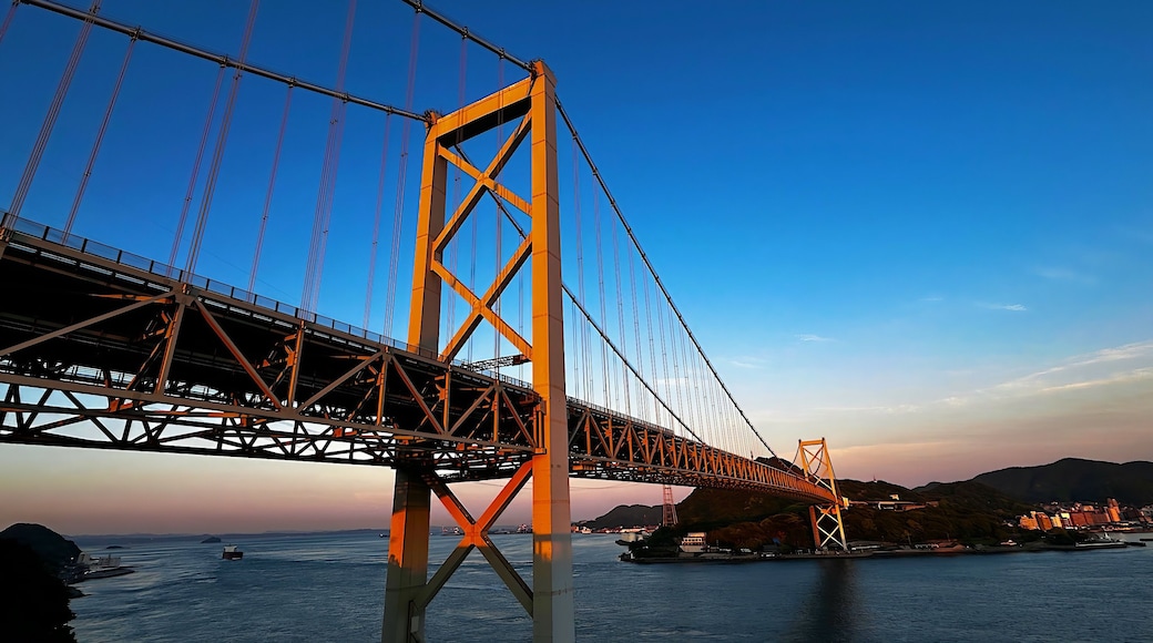 Majestic long view of the Kanmon Bridge illuminated by the setting sun at sunset, Shimonoseki, Japan