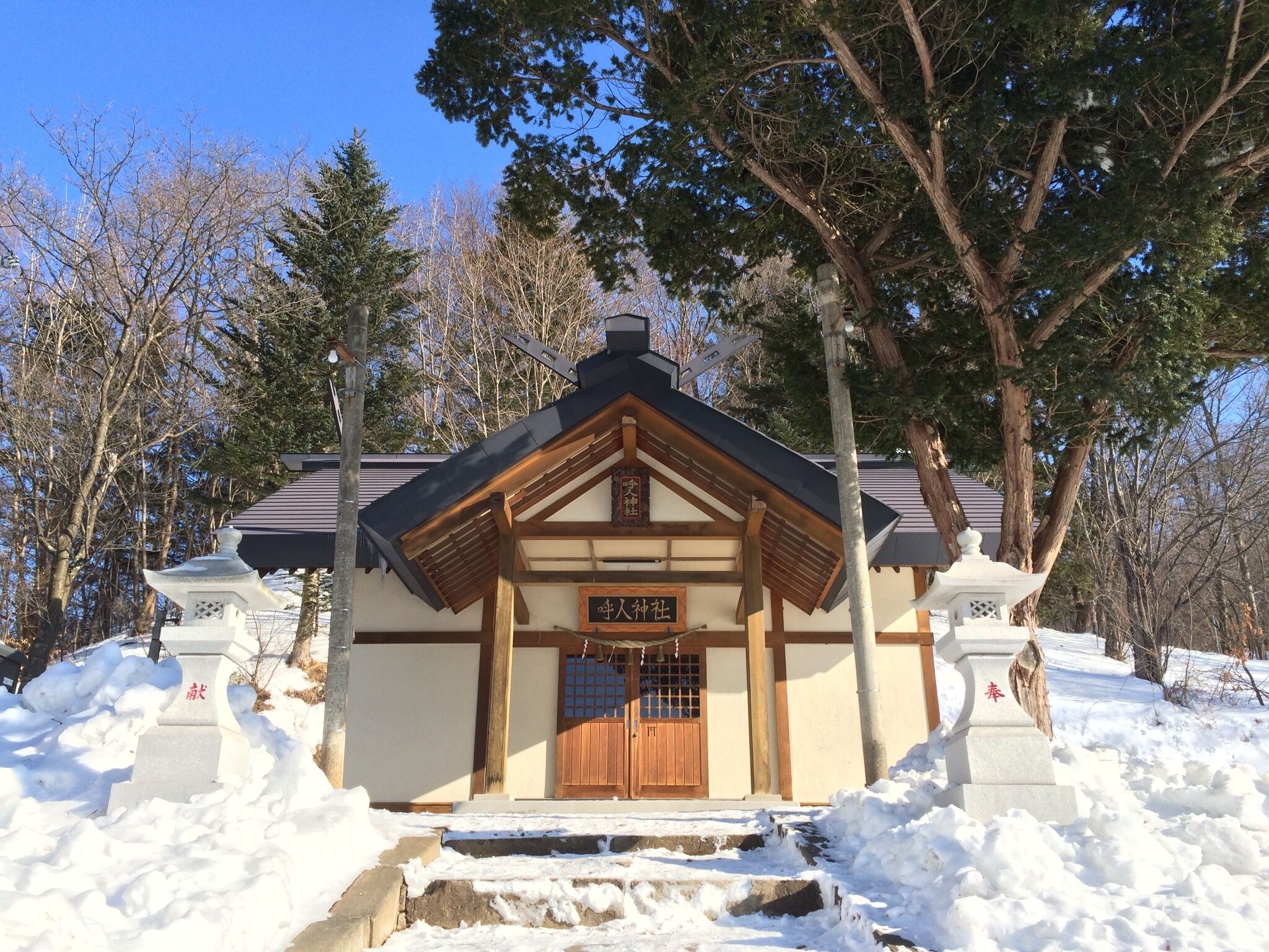 A traditional Japanese building with a wooden entrance and a signboard.