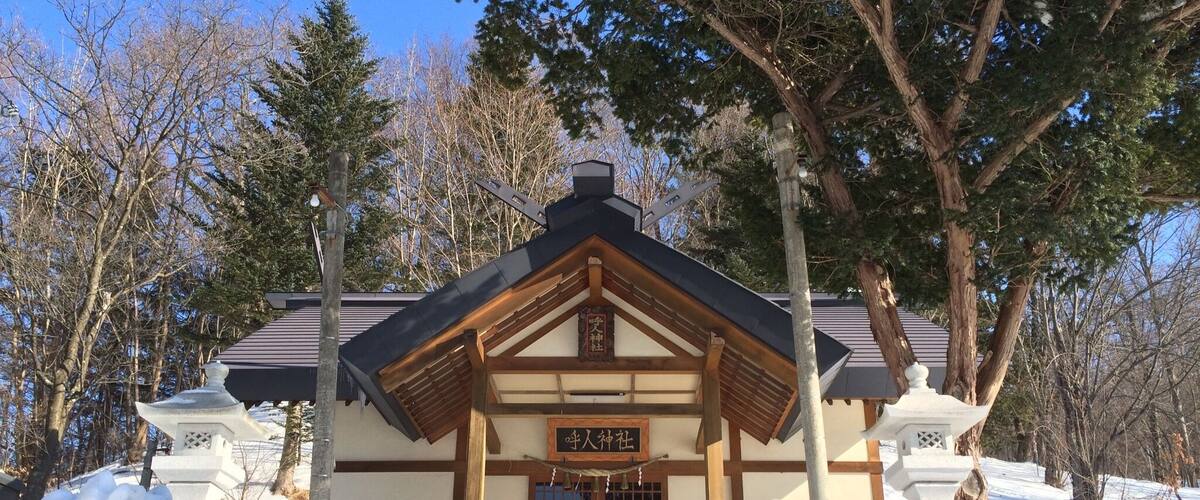 A traditional Japanese building with a wooden entrance and a signboard.