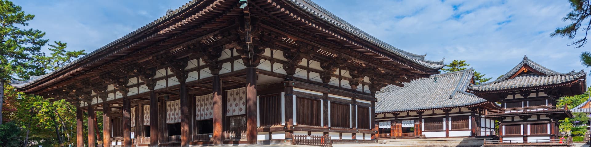 A traditional Japanese building with a tiled roof and wooden pillars.