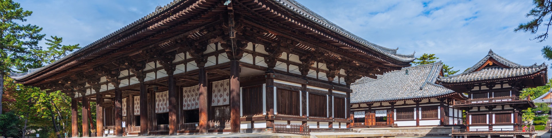 Um edifício japonês tradicional com telhado de telhas e colunas de madeira.