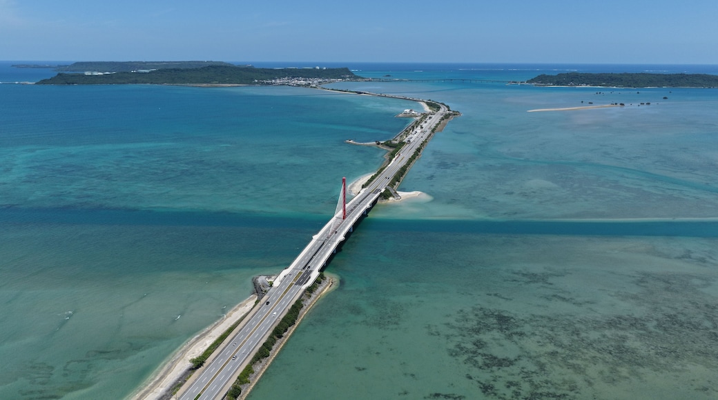 A long bridge spanning a body of water with clear blue water on both sides.