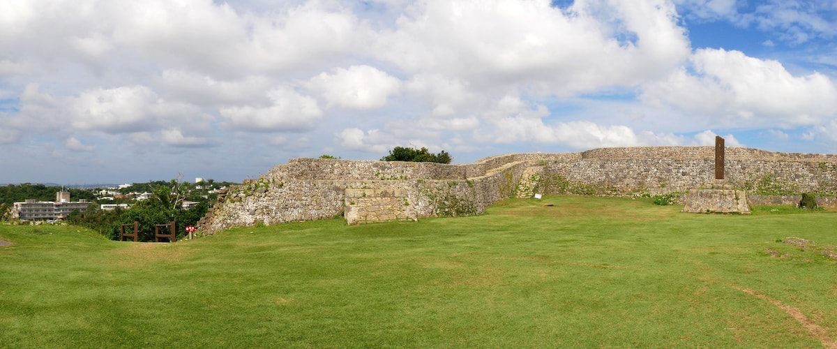 A stone fortification with a grassy foreground and a clear sky.