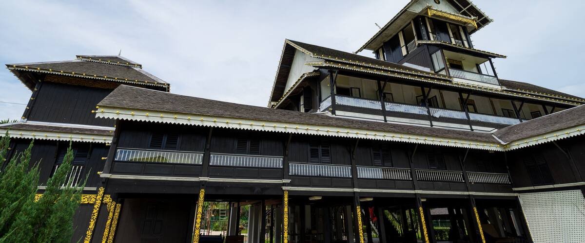 A traditional wooden building with multiple balconies and a steeply pitched roof.