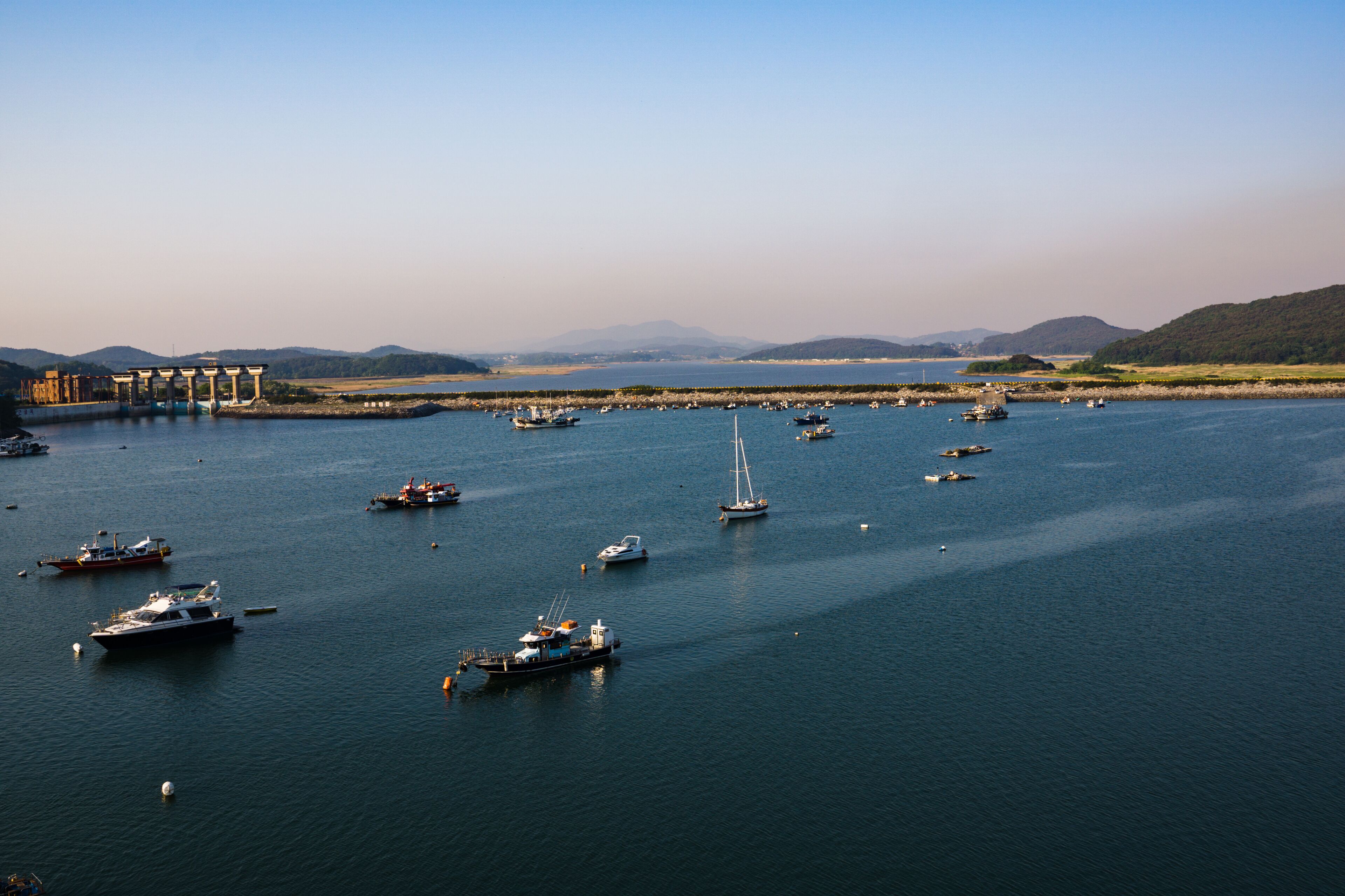 A marina with numerous boats and a distant mountain range.