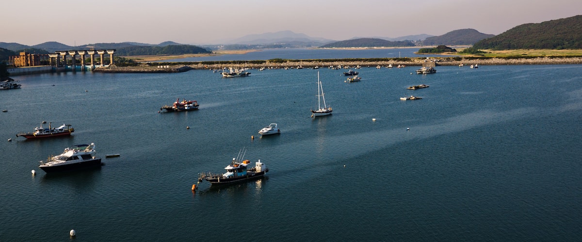 A marina with numerous boats and a distant mountain range.