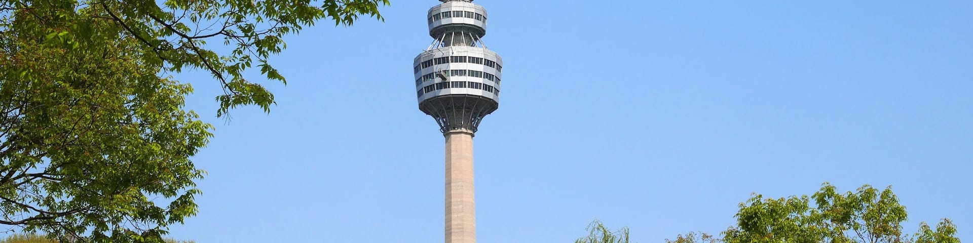 A tower with multiple levels, surrounded by trees and greenery.