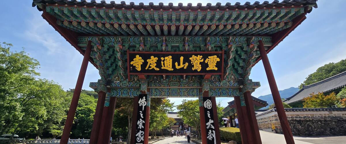 A traditional Chinese gate with intricate designs and a signboard.