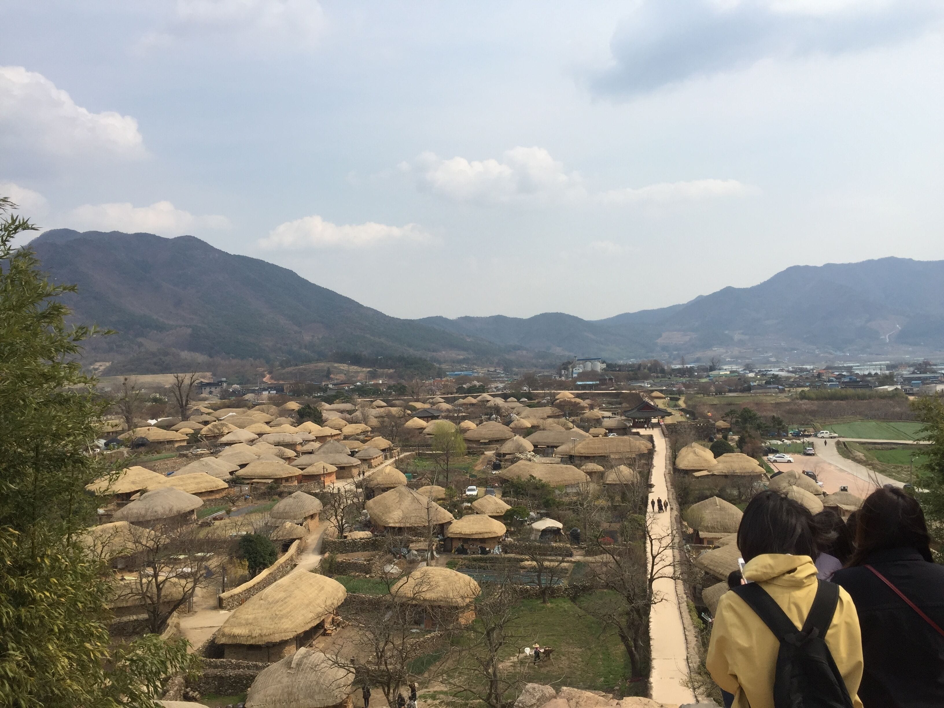 A village with thatched-roof houses and a mountain backdrop.
