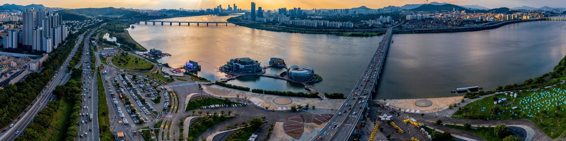A river with a bridge, a city skyline, and a highway.