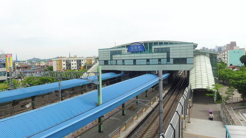 A modern train station with a blue roof and a distinctive white cylindrical structure.