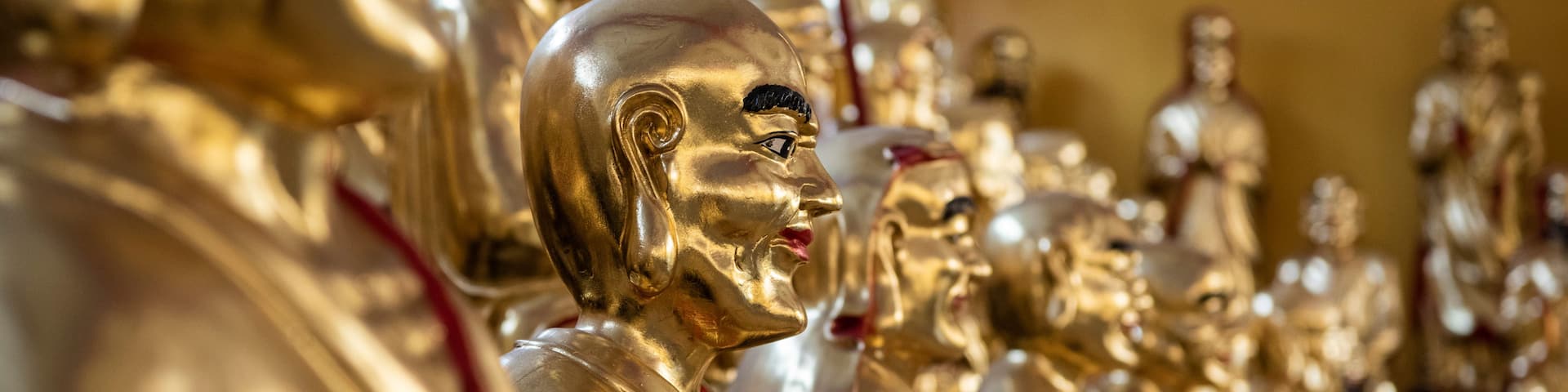 A row of golden statues with red markings.