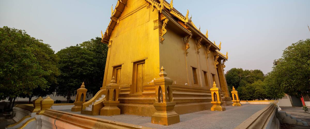 A golden temple with intricate architecture and a clear sky.
