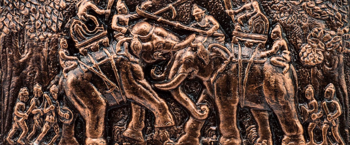 A detailed relief sculpture of a battle scene with warriors and elephants.