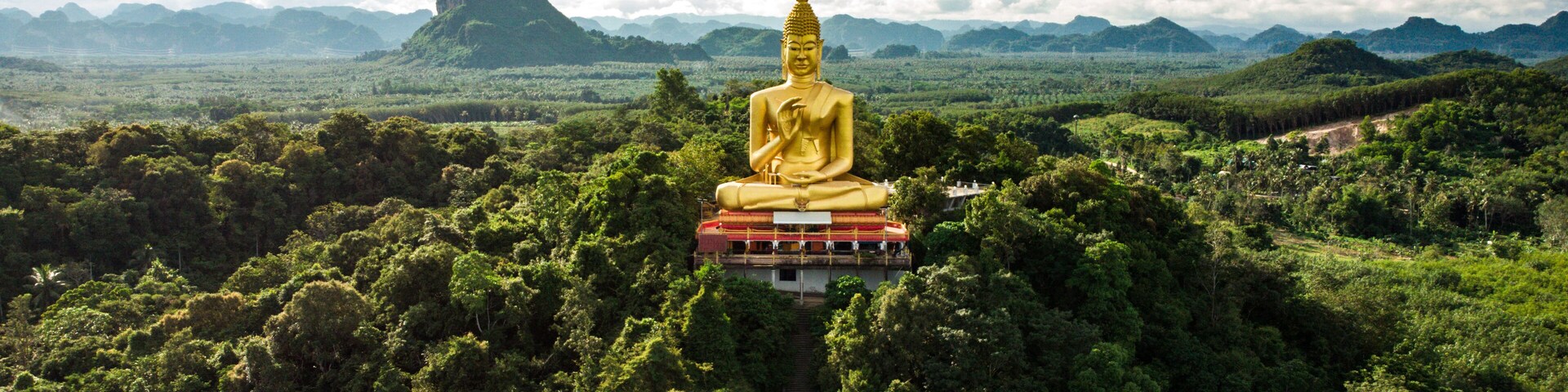 A buddha statue is standing on a mountain top in Chumphon region Thailand