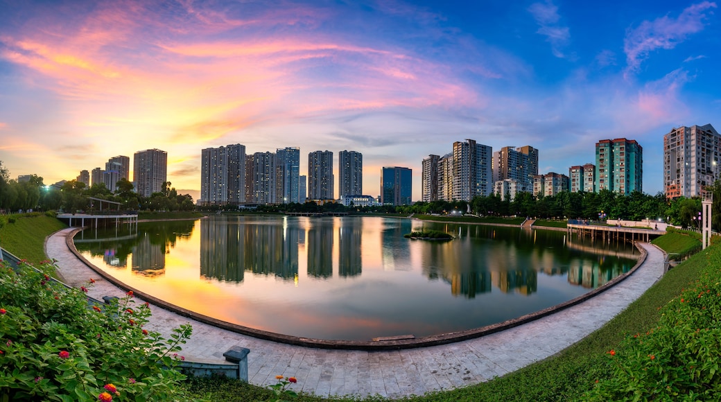 A cityscape with high-rise buildings, a calm lake, and a park with flowers.