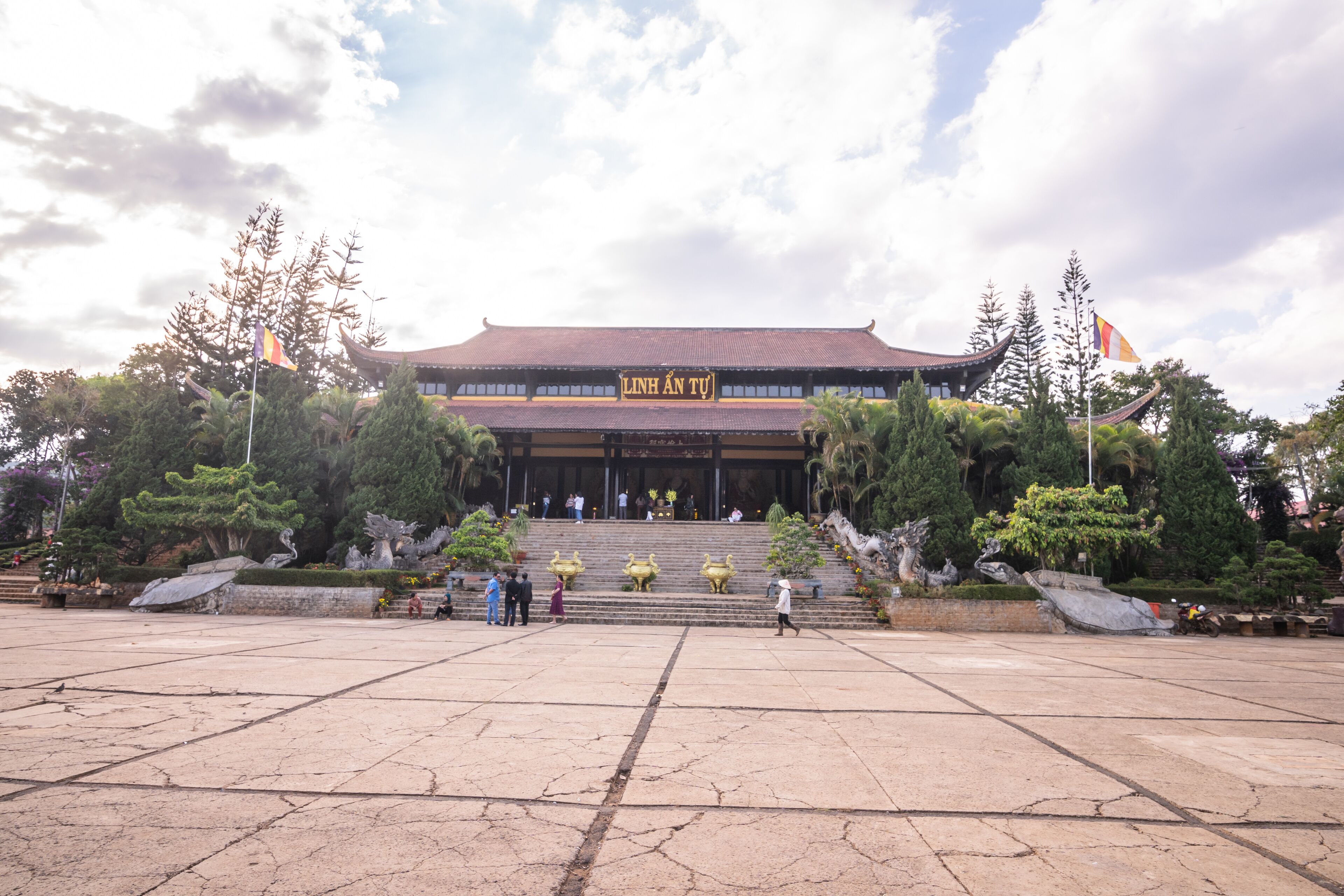 A traditional building with a tiled roof and a sign reading "LINH AN TU".
