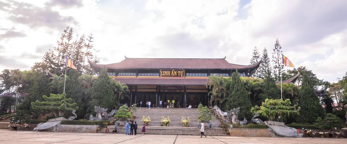 A traditional building with a tiled roof and a sign reading "LINH AN TU".