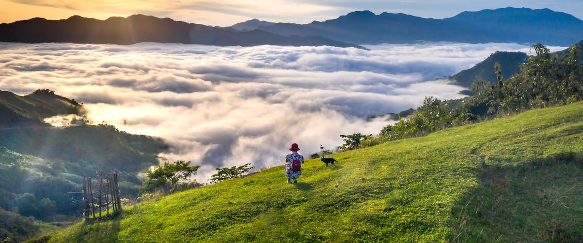 Panoramic view of sunrise with a trail going through a valley filled with white clouds in the Tak Po mountains in Tra Tap commune, Nam Tra My district, Quang Nam province, Vietnam