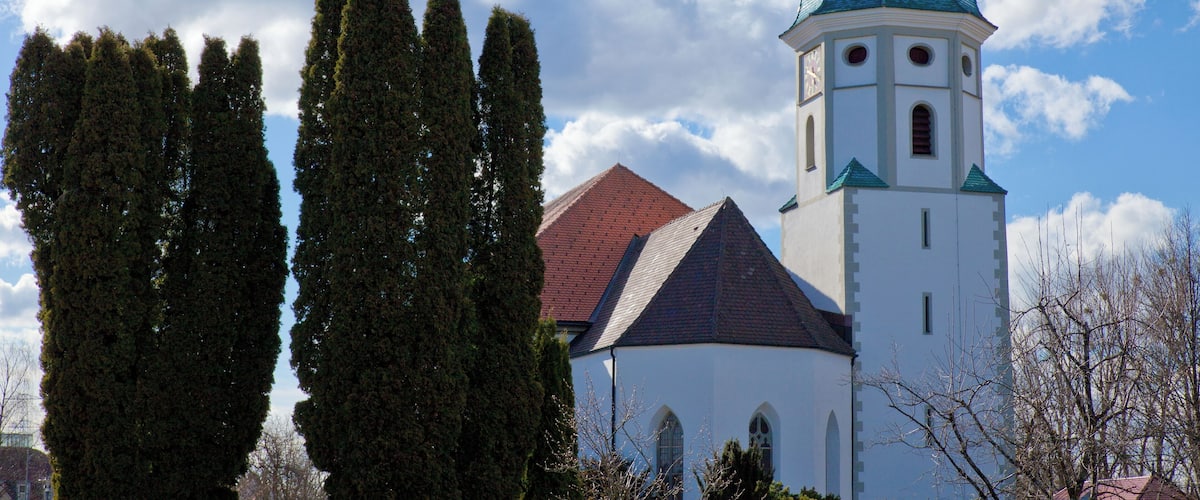 A church with a green spire and white walls.
