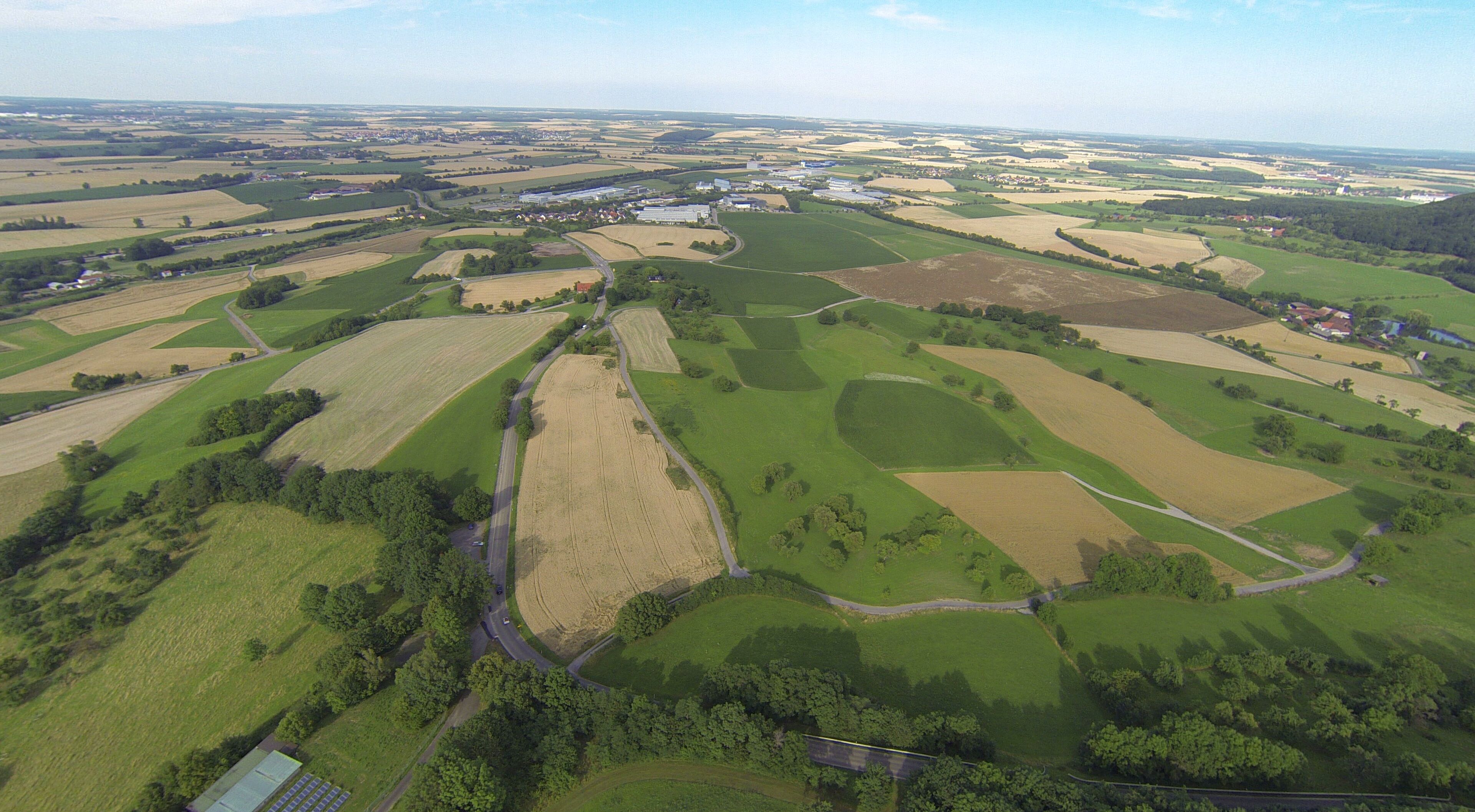 An aerial view of a rural landscape with fields, roads, and scattered buildings.