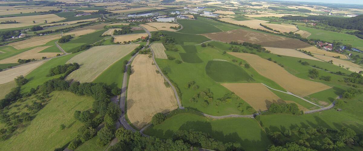 An aerial view of a rural landscape with fields, roads, and scattered buildings.