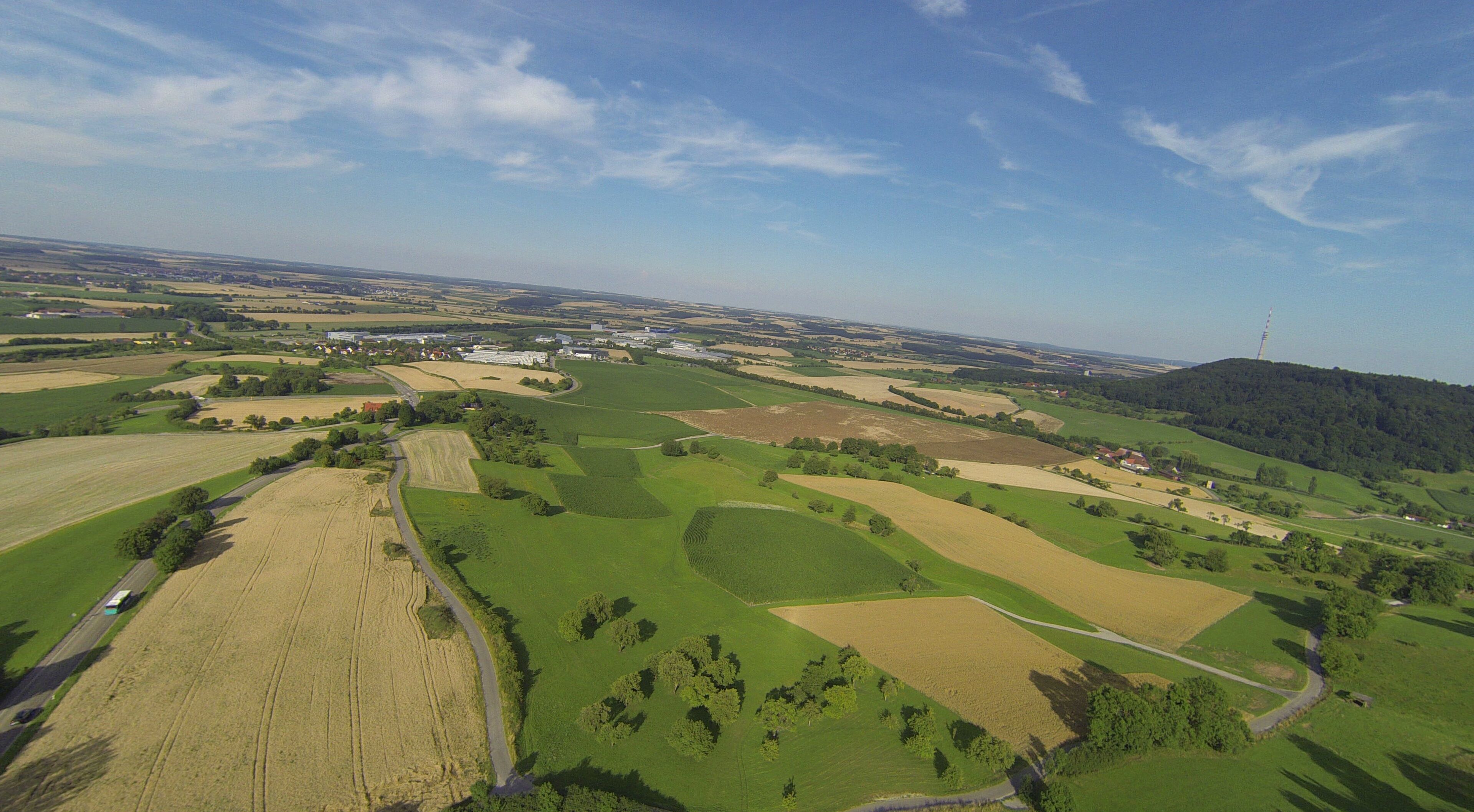An aerial view of a rural landscape with fields, roads, and scattered buildings.