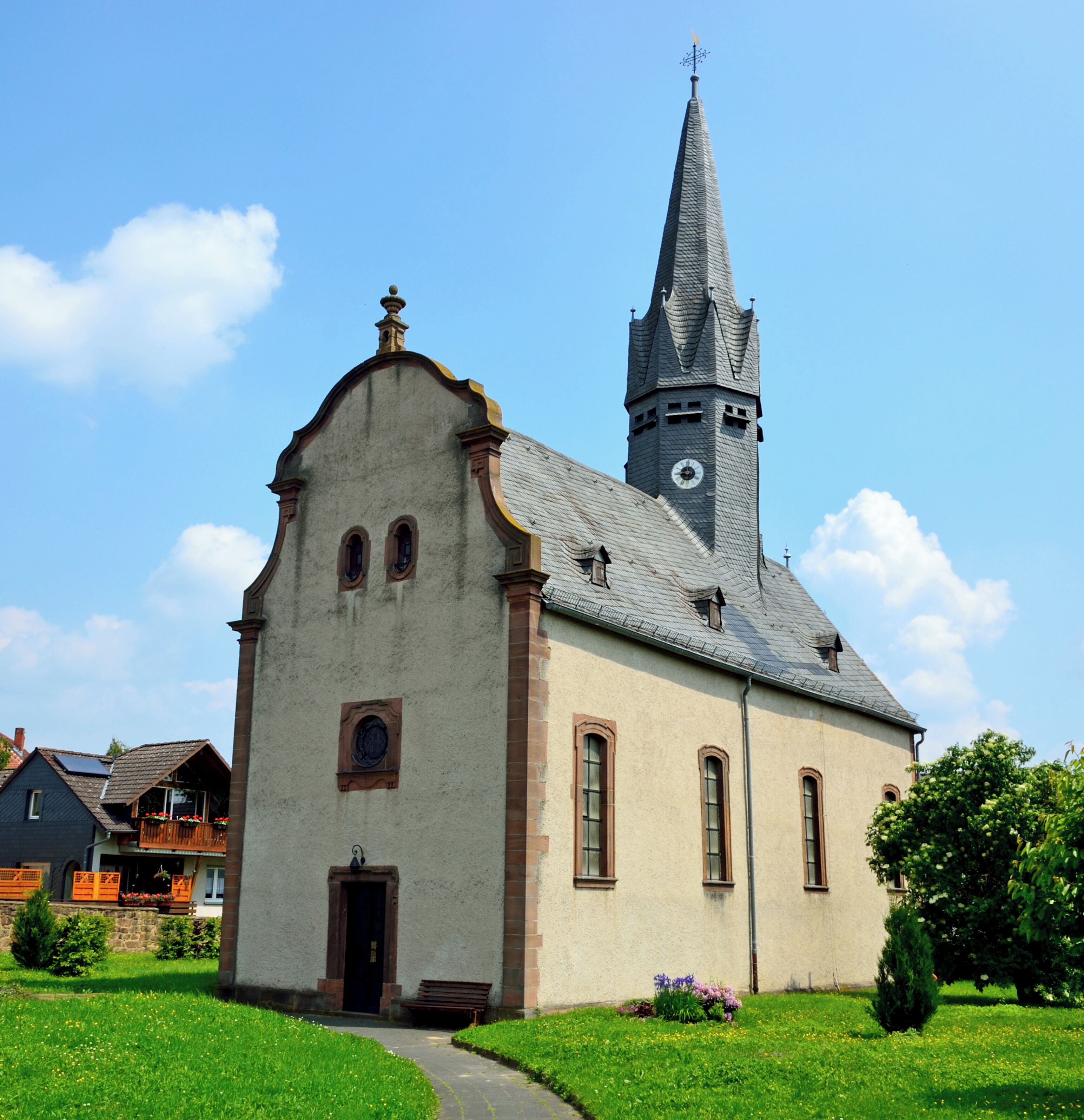 A church with a tall steeple and a clock tower.