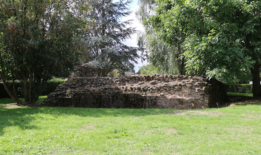 An ancient stone structure surrounded by lush greenery.