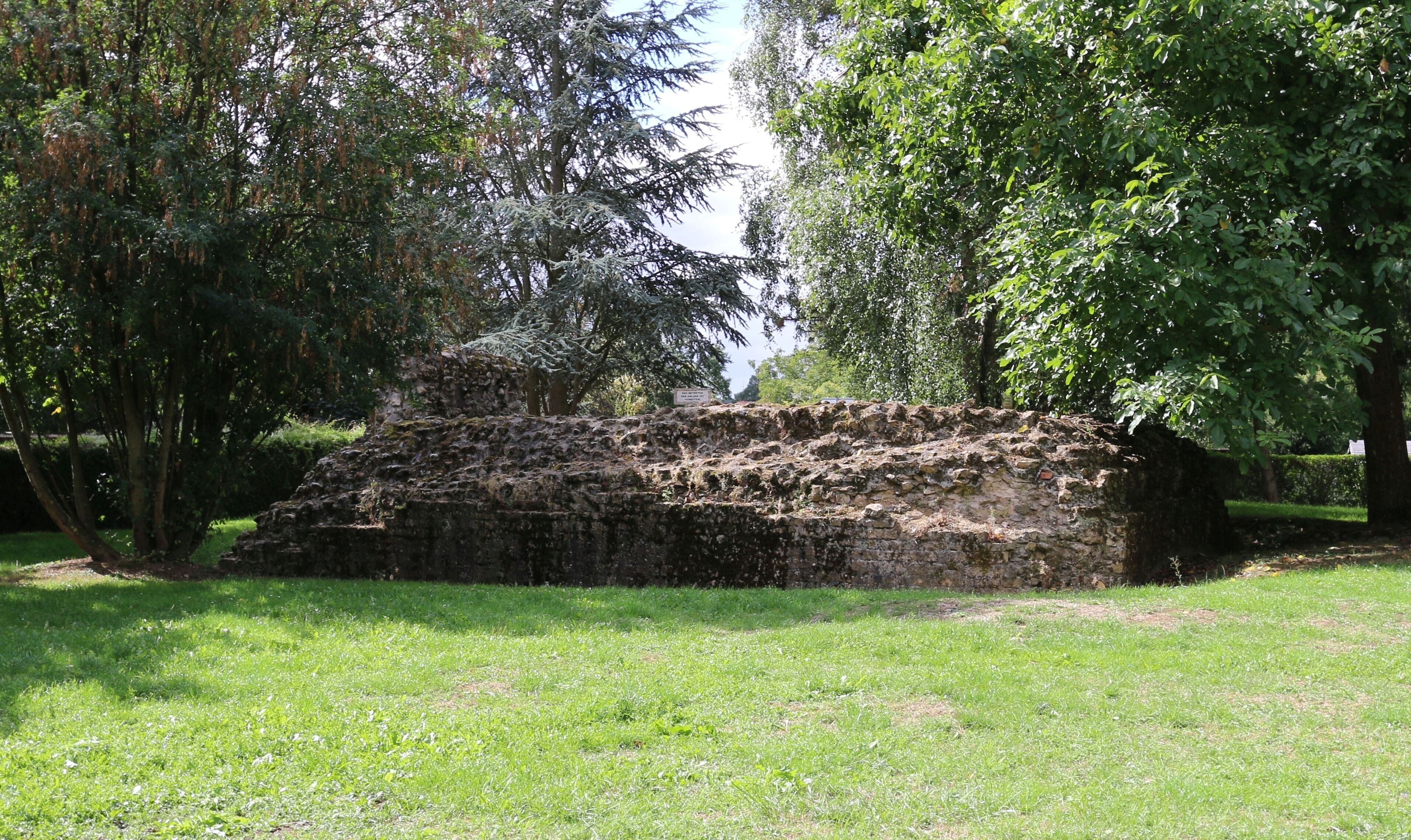 An ancient stone structure surrounded by lush greenery.