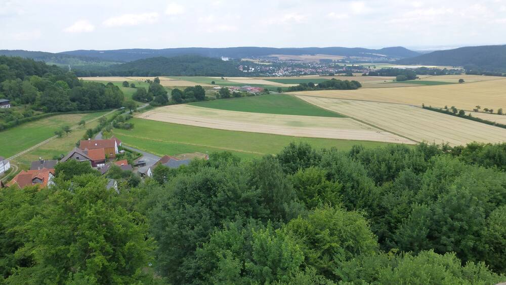 Ländliche Landschaft mit Feldern, Häusern und einem Dorf im Tal.