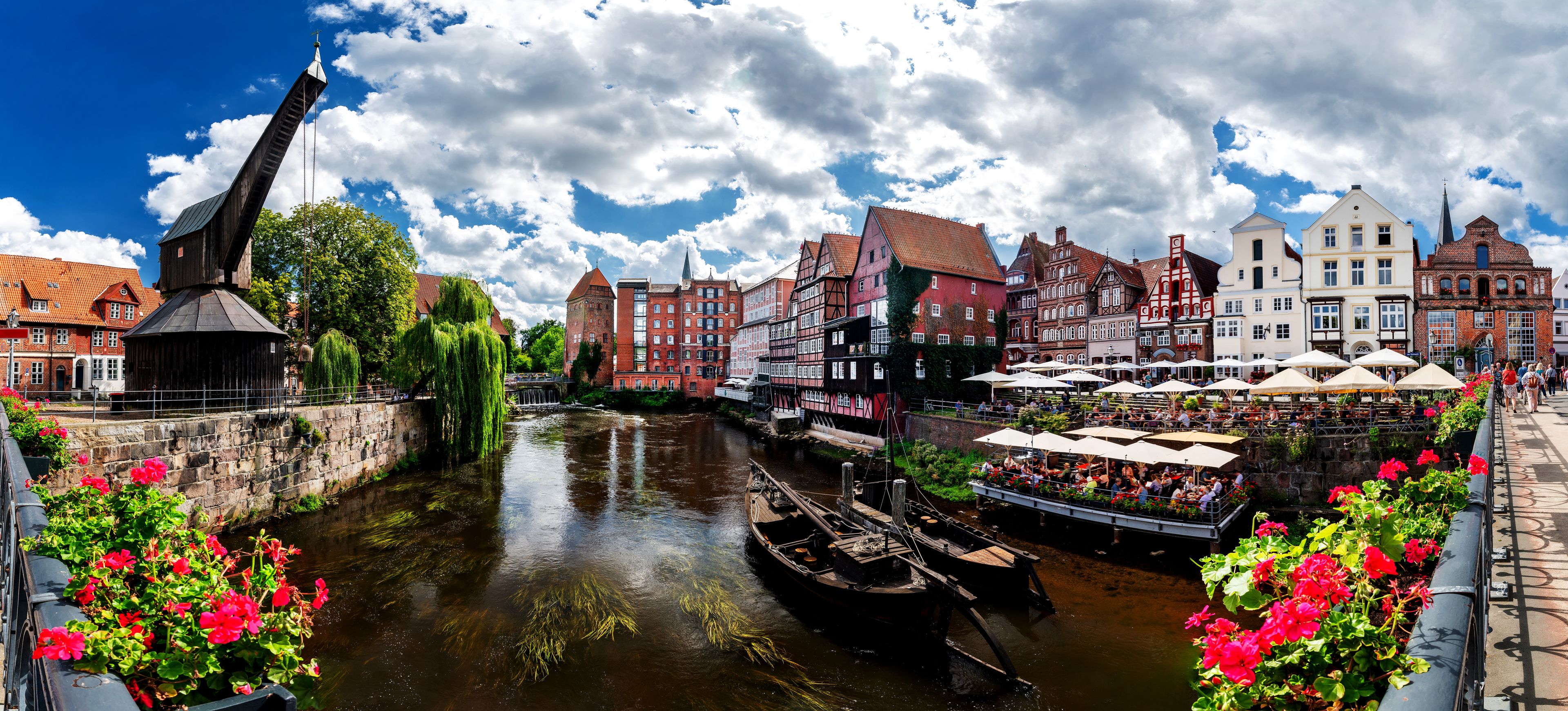 A river with boats, historic buildings, and a bridge.