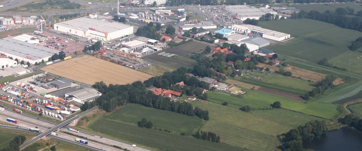 An industrial area with factories, a highway, and surrounding farmland.