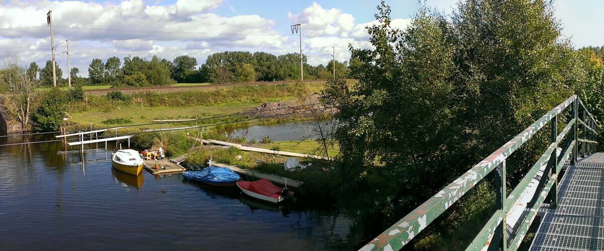 A bridge over a river with boats docked at the side.