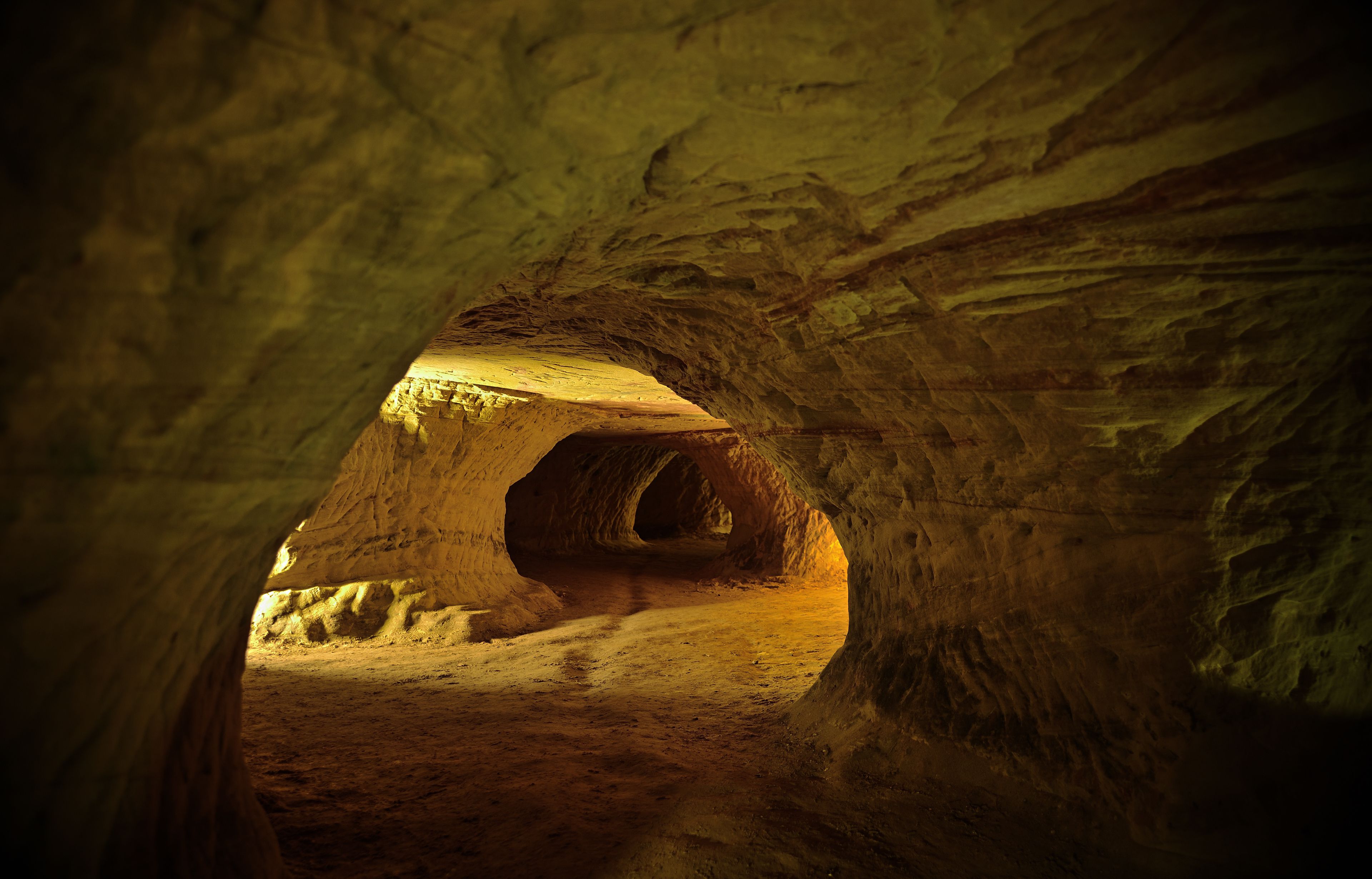 A cave with a natural archway and a tunnel inside.