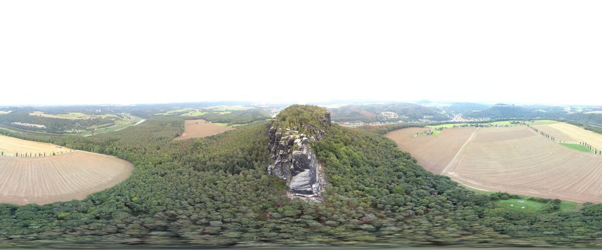 A large forested area with a prominent cliff and a river running through it.