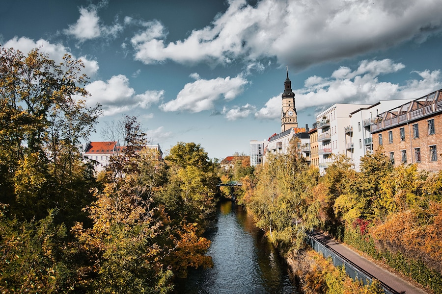 River runs through the town,
Embraced by autumnal trees and a church that rises majestically in the light.