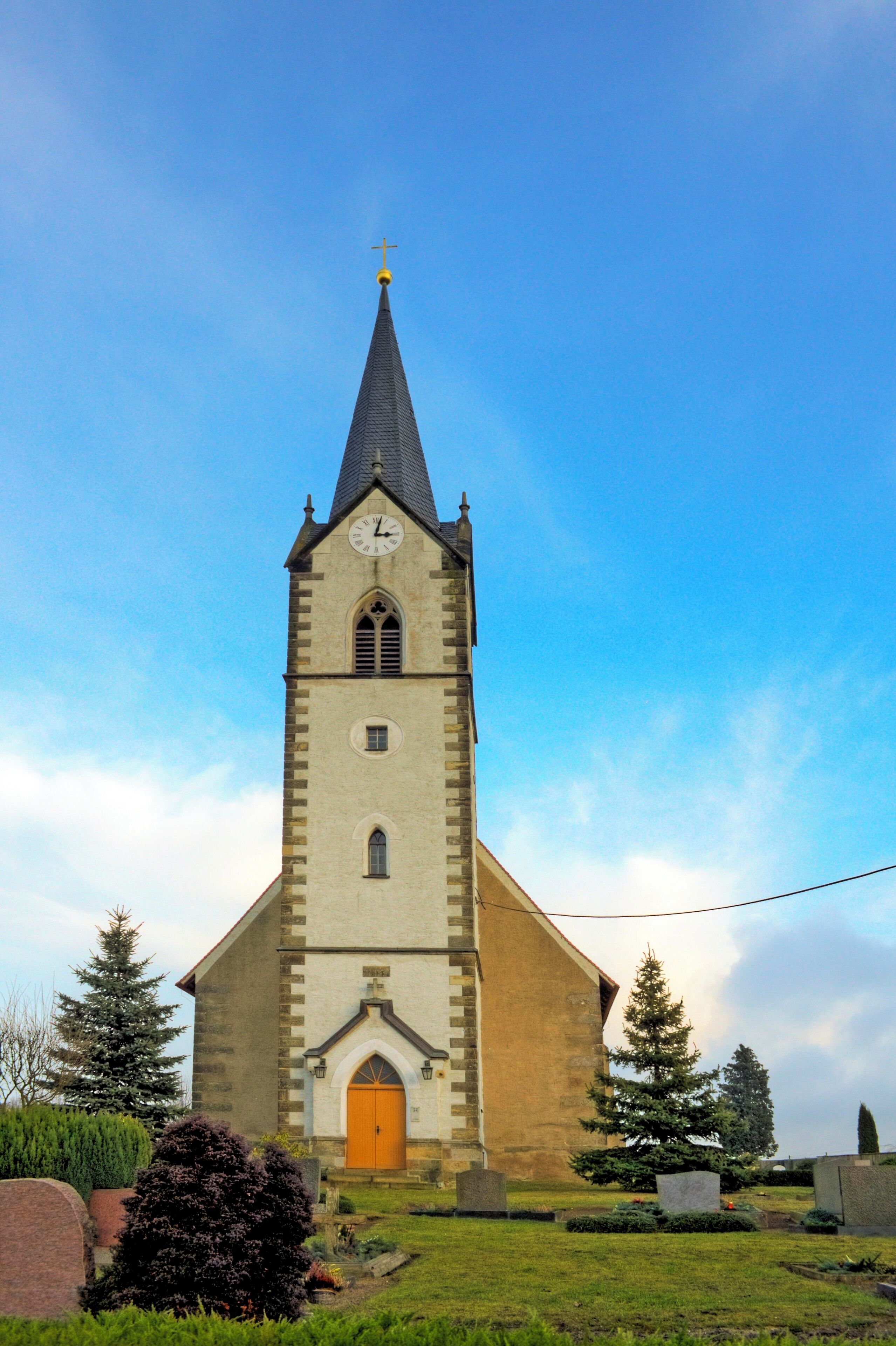 A church with a tall steeple and a clock.